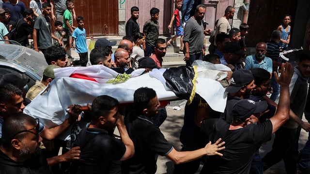 Mourners carry the body of Palestinian man Mohammad al-Waheidi, who worked for the Egyptian Relief Committee and was killed in an Israeli strike on Tuesday, during his funeral, in Gaza 