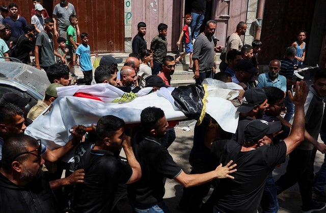 Mourners carry the body of Palestinian man Mohammad al-Waheidi, who worked for the Egyptian Relief Committee and was killed in an Israeli strike on Tuesday, during his funeral, in Gaza 