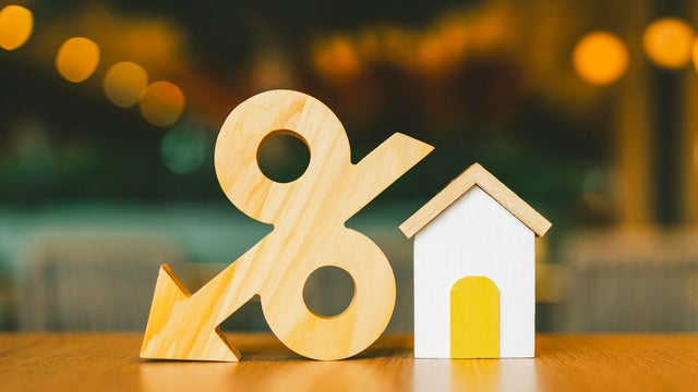 Percentage and house symbol on wood table. Concepts of home interest, real estate, investing in inflation. 