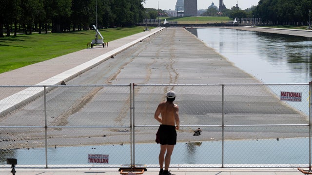 A person stops to look at the partially-drained Lincoln Memorial Reflecting Pool, Monday, July 13, 2026, in Washington. 