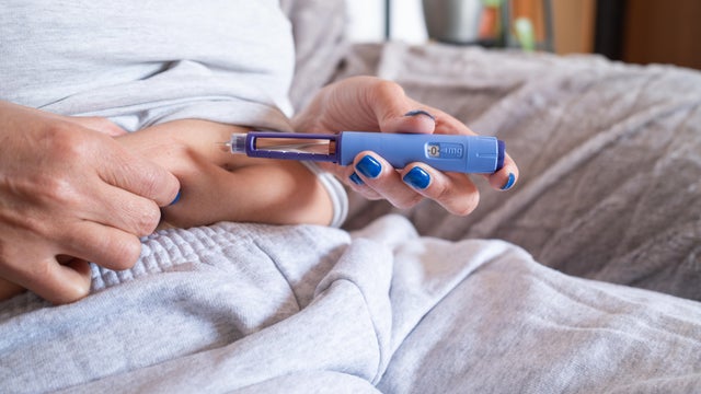 unrecognizable mature overweight diabetic woman injecting a syringe of semaglutide into her belly.medication for the medical treatment of obesity. 