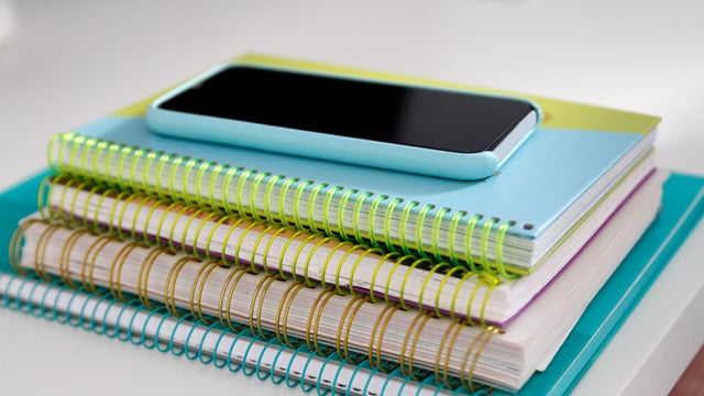 Stack of notepads and smartphone on desk 