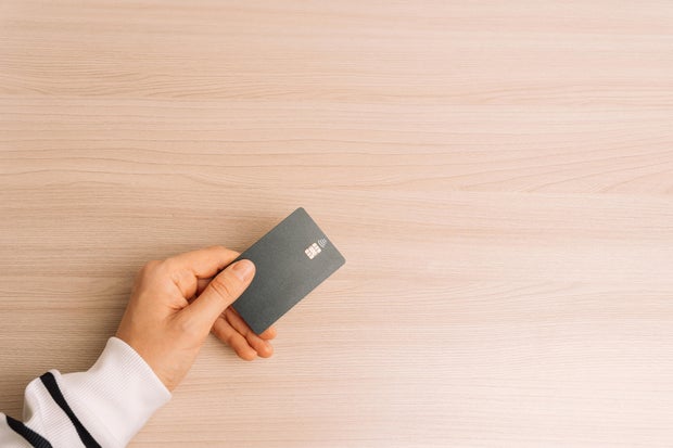 Hand Holding Contactless Card on Wooden Table