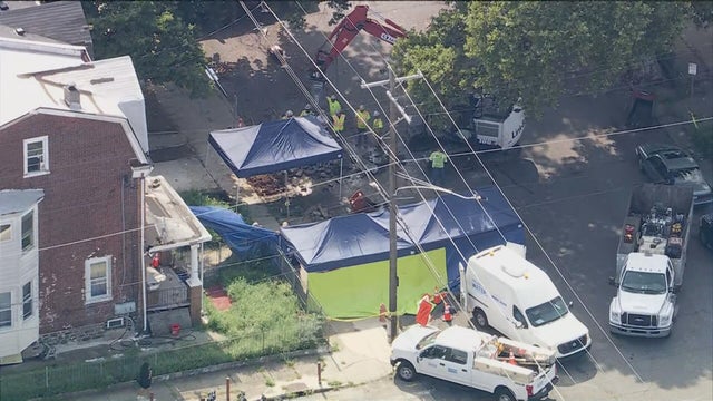 Chopper shot showing tents and construction vehicle near a house that's under investigation in Olney 