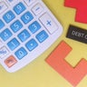 Calculator and debt collection concept on yellow background 