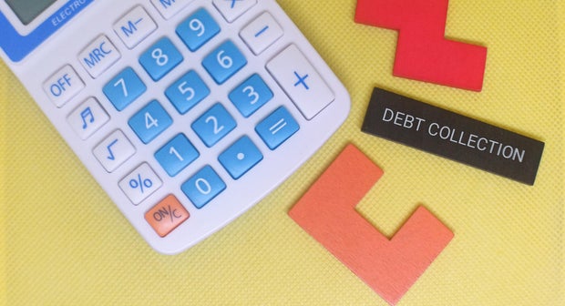 Calculator and debt collection concept on yellow background