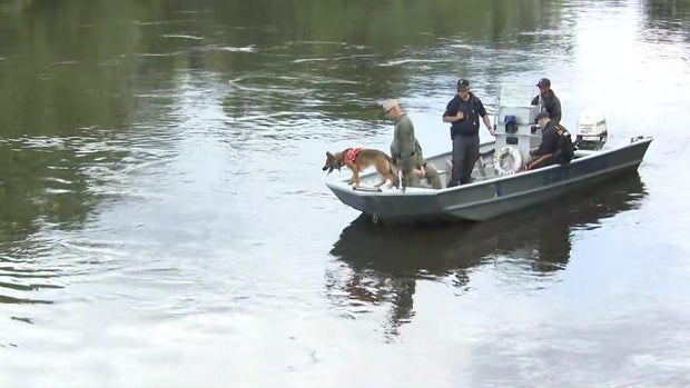 Search crews in a boat on the river