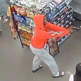Surveillance image of a man pointing a gun inside a store 