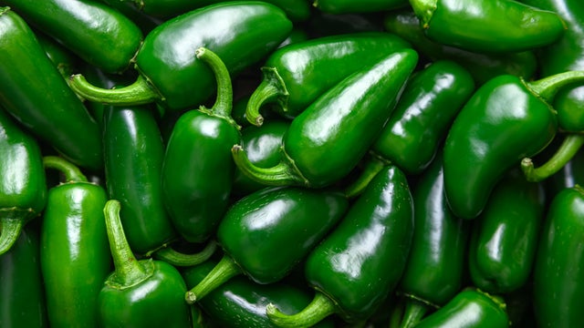 Heap of green mexican jalapeno hot peppers close up 