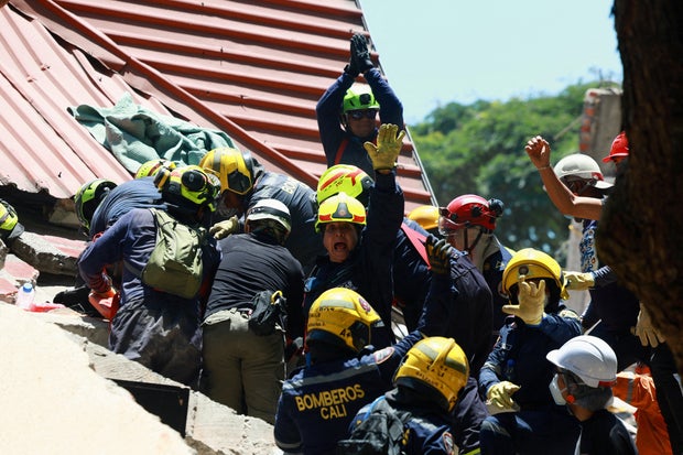 Firefighters react as they rescue a person following an earthquake, in Cali, Colombia, Aug. 11, 2026.
