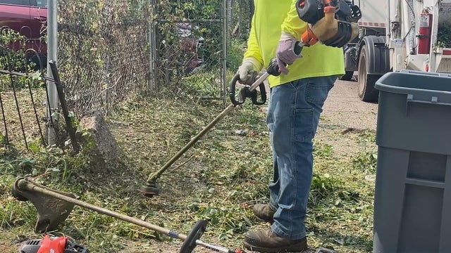 A man uses a weed whacker at a vacant house in Philadelphia 