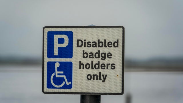 Disabled Badge Holders Only Parking Sign on a Coastal Road in Suffolk, England 