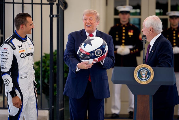 Penske Corp. CEO Roger Penske and IndyCar champion Álex Palou present President Trump with a race helmet at the White House on July 13, 2026. 