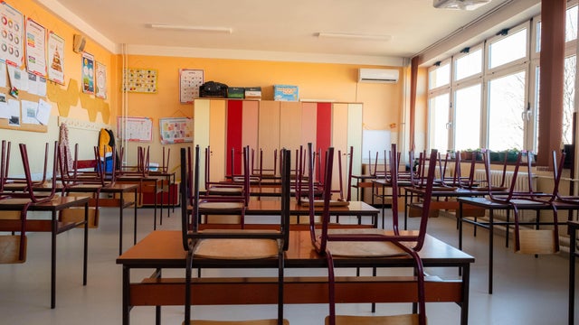 Empty classroom with chairs on desks after school closing 