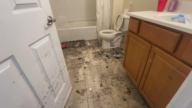 Water and dirt are seen in the bathroom of a home after a flood 