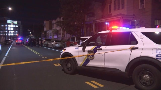 A police car with lights on and police tape at the scene of a shooting on West Westmoreland Street in Philadelphia's Tioga neighborhood 