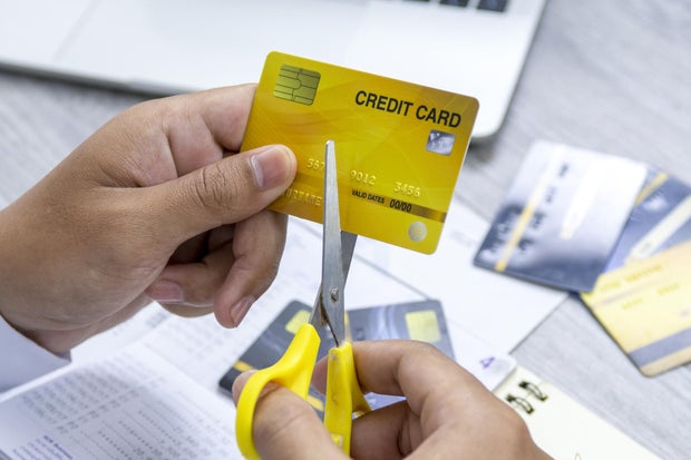 A man cutting a credit card with scissors for stop making debt from it. 