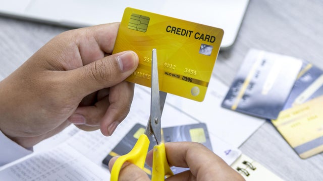 A man cutting a credit card with scissors for stop making debt from it. 