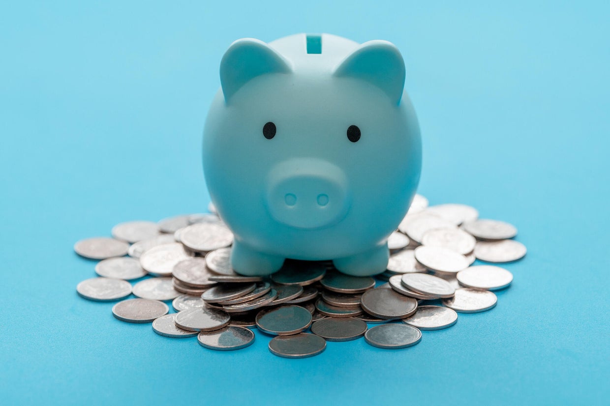 Piggy bank and coin on light blue background for money savings. Earning interest on savings. Growing your wealth and saving money concept