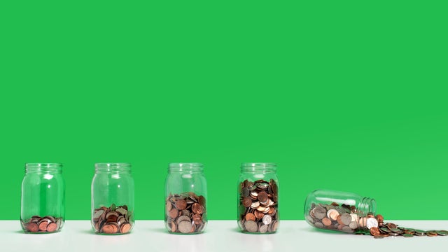 Savings fail - Financial growth with spilling coin jar 
