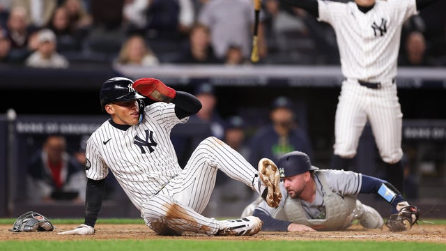 George Lombard Jr. #96 of the New York Yankees avoids a tag by Liam Hicks #34 of the Tampa Bay Rays to score a run during the seventh inning of the game at Yankee Stadium on September 24, 2026 in New York City. 