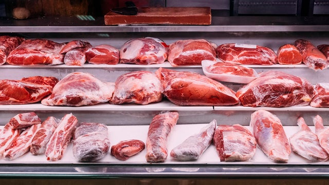Assorted beef cuts displayed on refrigerated butcher shelves 