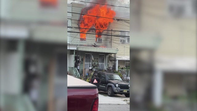 Flames shooting out of second-floor windows of a home 