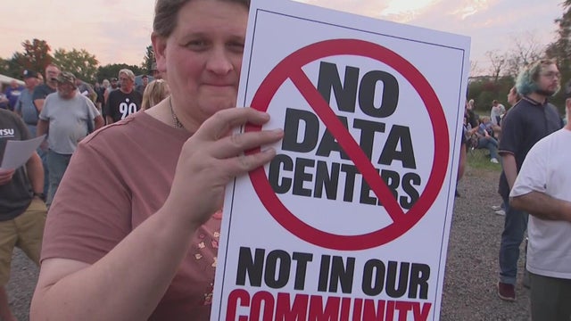Crowd boos data center developer during contentious meeting