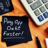 Pay off debt faster handwritten memo and calculator. 