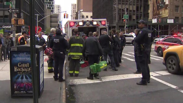 NYPD and FDNY personnel around an ambulance at 53rd Street and Seventh Avenue.