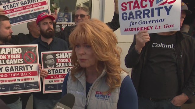 Stacy Garrity stands with skill game operators while speaking at rally