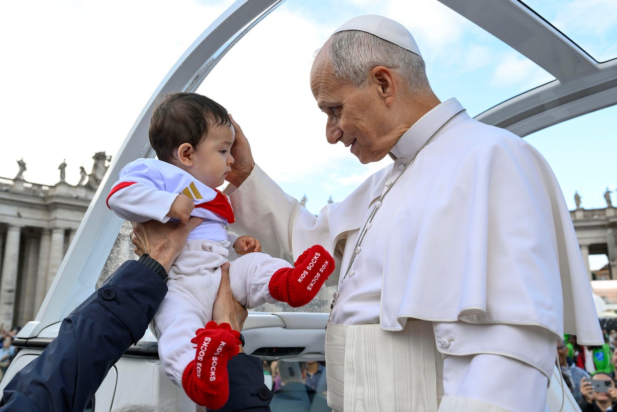 Pope Leo XIV blesses a child during his weekly general audience in St. Peter's Square in Vatican City, Oct. 21, 2026.