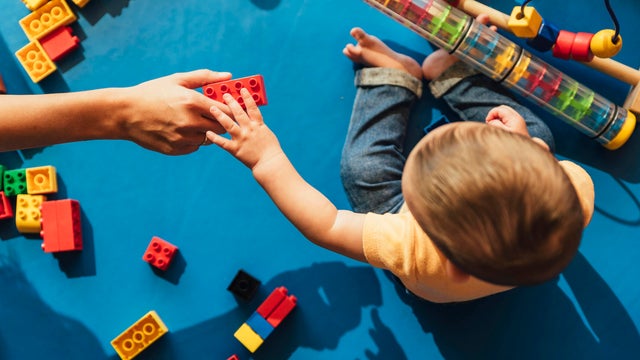 Happy baby playing with toy blocks. 