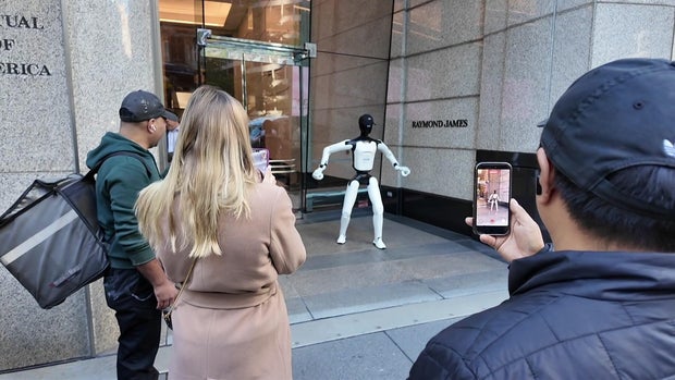People take videos of a humanoid robot