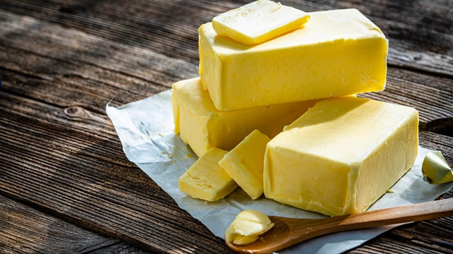 Butter blocks and pieces on wooden table 