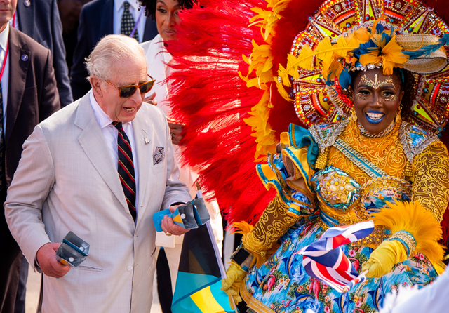King Charles III is seen with a performer during the celebratory Junkanoo street parade in Parliament Square, Nassau, during his royal visit to the Bahamas, Oct. 28, 2026. Aaron Chown/PA Images/Getty